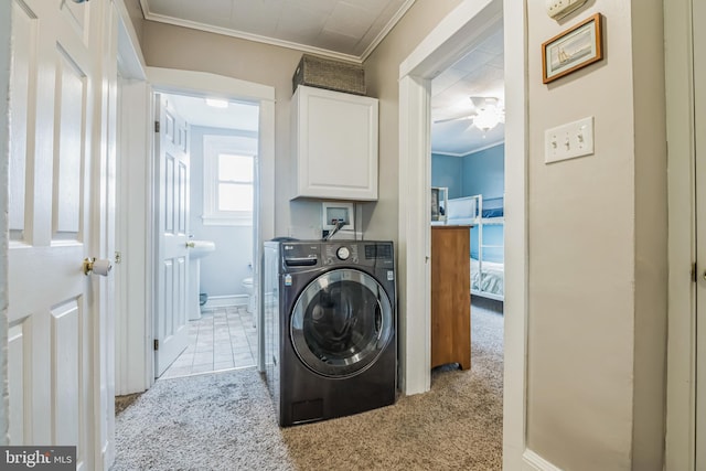 laundry area with ornamental molding, light colored carpet, cabinets, and washer / clothes dryer