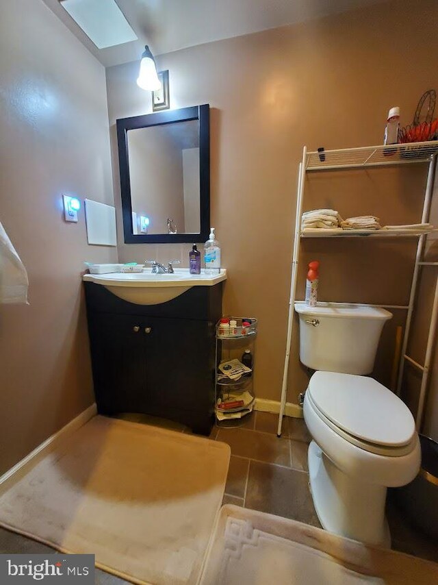 bathroom with vanity, tile patterned flooring, and toilet