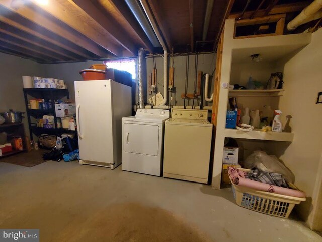 basement featuring washer and clothes dryer and white fridge