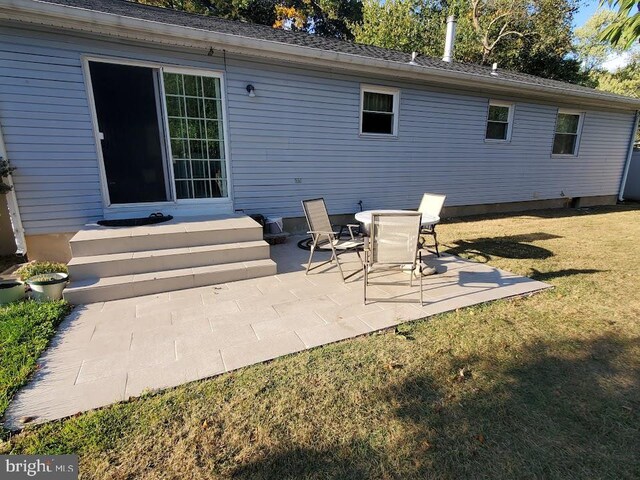 back of property with a yard and a patio area