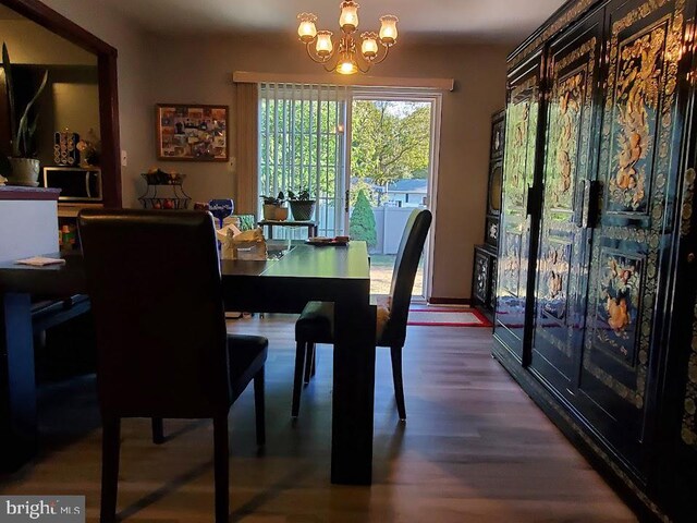 dining area featuring wood-type flooring and a chandelier