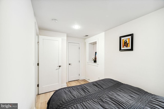 bedroom featuring baseboards, visible vents, and light wood-style flooring