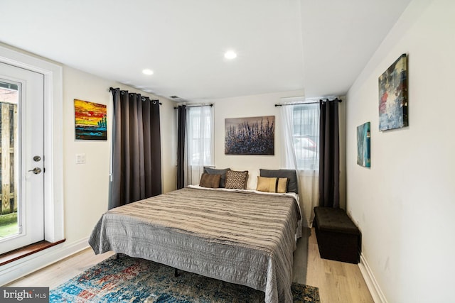 bedroom with multiple windows and light hardwood / wood-style floors