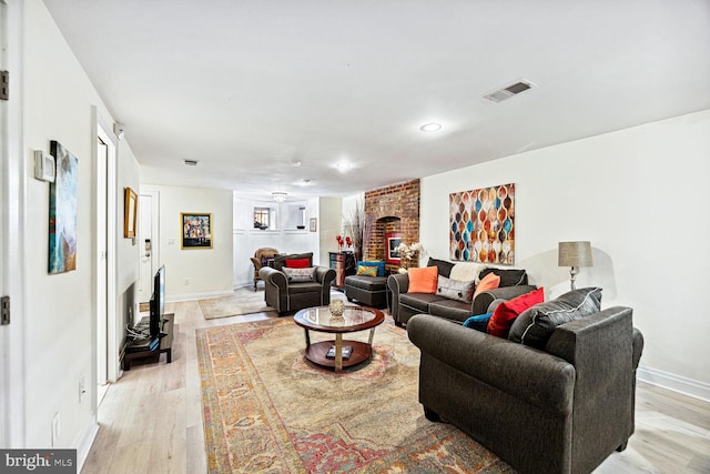 living room with light hardwood / wood-style flooring, a fireplace, and ceiling fan