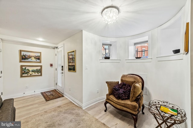 living area with light hardwood / wood-style flooring and a notable chandelier