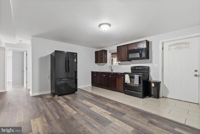 kitchen featuring light hardwood / wood-style floors, black appliances, sink, and dark brown cabinets