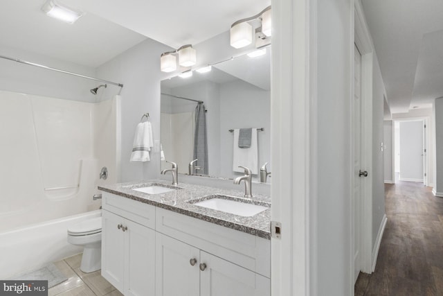 full bathroom featuring vanity, toilet, tub / shower combination, and hardwood / wood-style floors