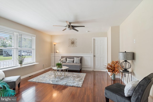 living room with ceiling fan and dark hardwood / wood-style flooring