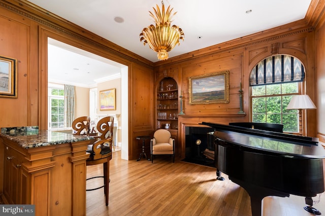 interior space featuring ornamental molding, a chandelier, and light hardwood / wood-style floors