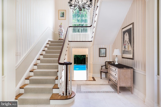 tiled foyer entrance featuring an inviting chandelier