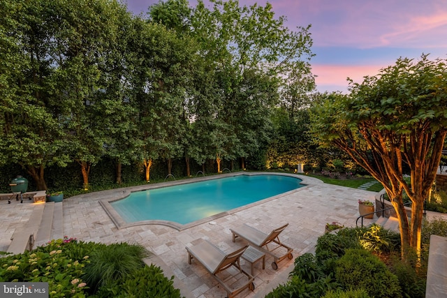 pool at dusk with a patio