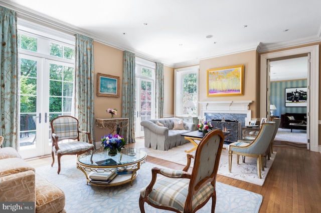 living room featuring ornamental molding, a fireplace, hardwood / wood-style floors, and a wealth of natural light