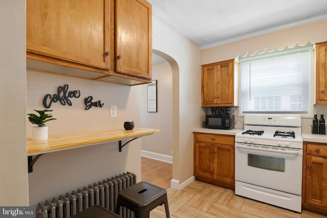 kitchen featuring radiator heating unit, light hardwood / wood-style flooring, and white gas range