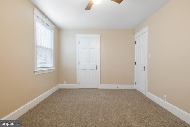 unfurnished room featuring ceiling fan and carpet flooring