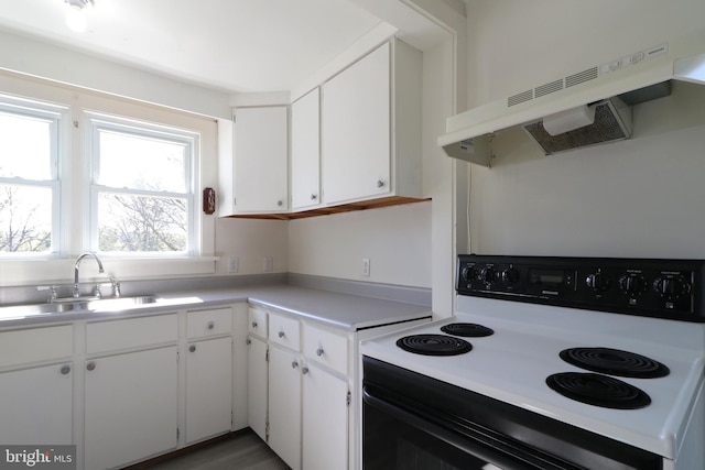 kitchen with white cabinetry, sink, hardwood / wood-style floors, electric stove, and exhaust hood