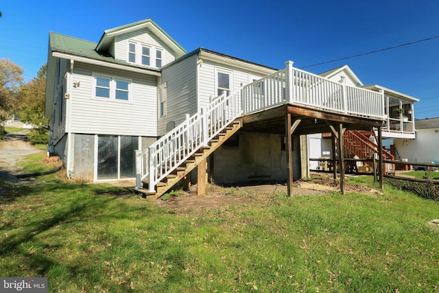 rear view of house with a wooden deck and a yard