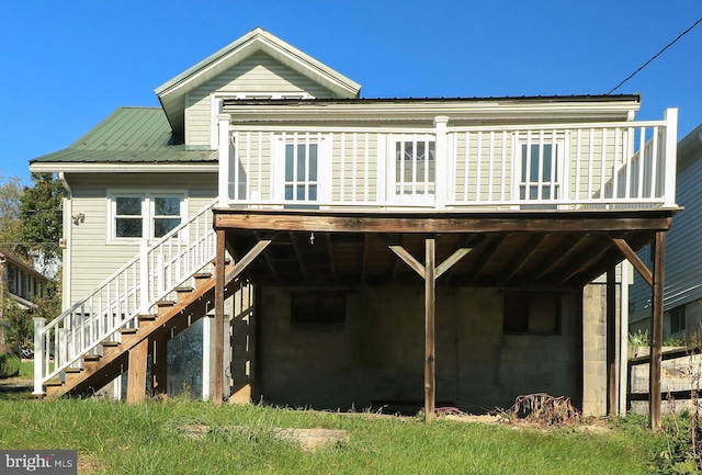 rear view of house featuring a wooden deck