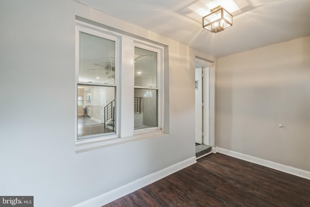 unfurnished room with dark hardwood / wood-style flooring