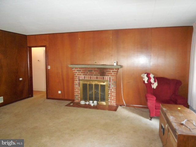 carpeted living room with a fireplace and wood walls