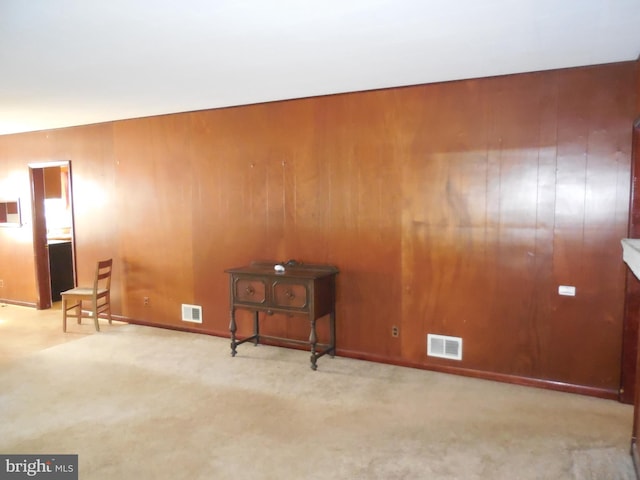 carpeted spare room with wood walls