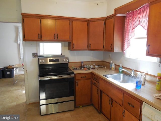 kitchen with white dishwasher, sink, stainless steel range with electric cooktop, and light tile patterned floors