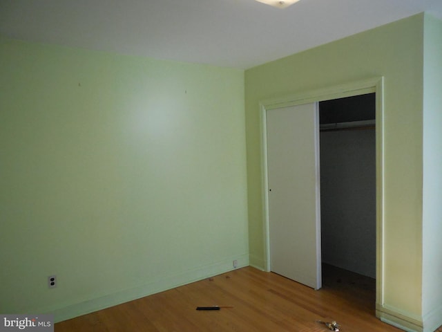 unfurnished bedroom with a closet and light hardwood / wood-style floors