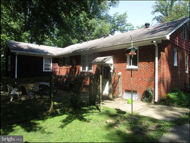 back of property featuring a lawn