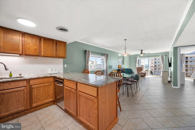 kitchen with light tile patterned flooring, sink, tasteful backsplash, kitchen peninsula, and light stone countertops