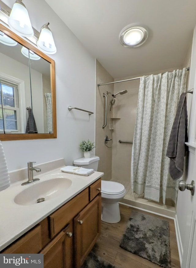 bathroom featuring curtained shower, hardwood / wood-style floors, vanity, and toilet