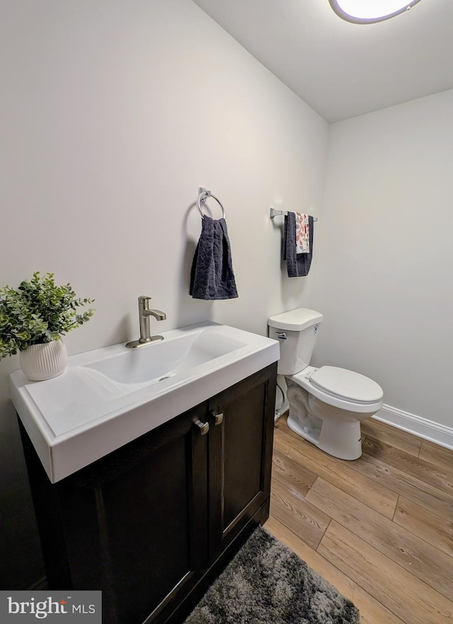 bathroom featuring vanity, wood-type flooring, and toilet