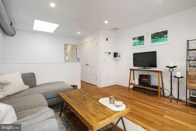 living room with a skylight and hardwood / wood-style flooring