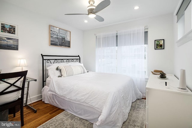 bedroom with multiple windows, hardwood / wood-style flooring, and ceiling fan