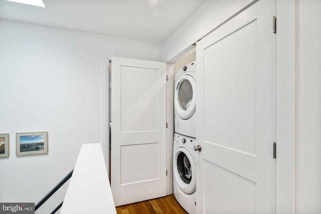 washroom featuring stacked washing maching and dryer and light hardwood / wood-style floors