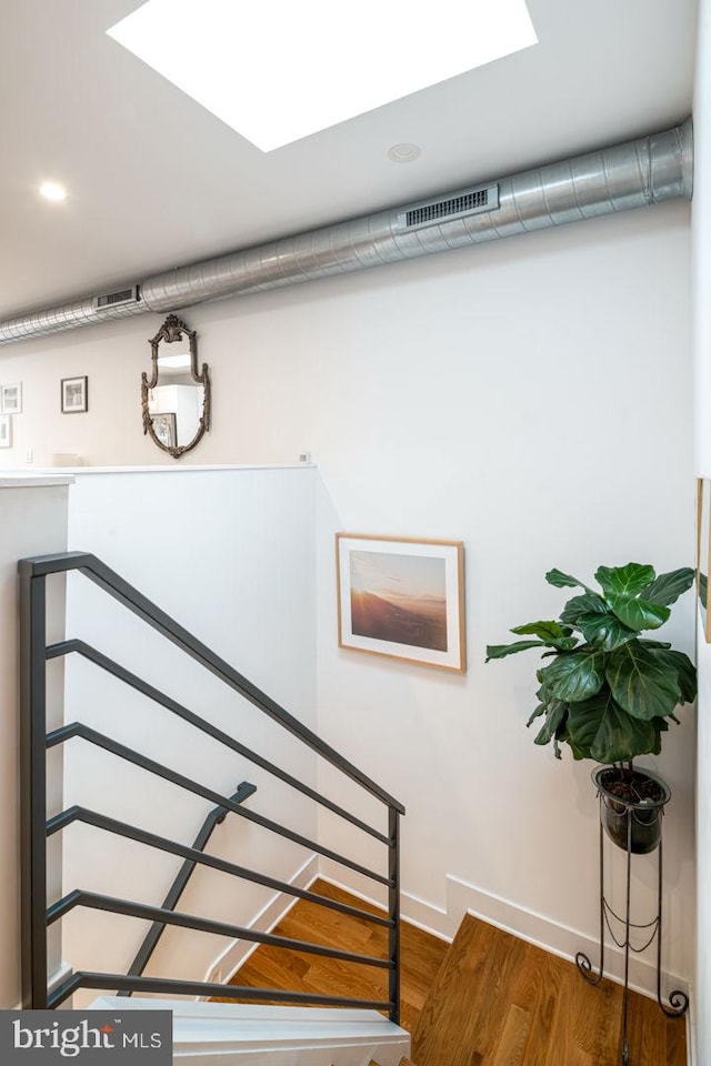 stairs featuring hardwood / wood-style floors