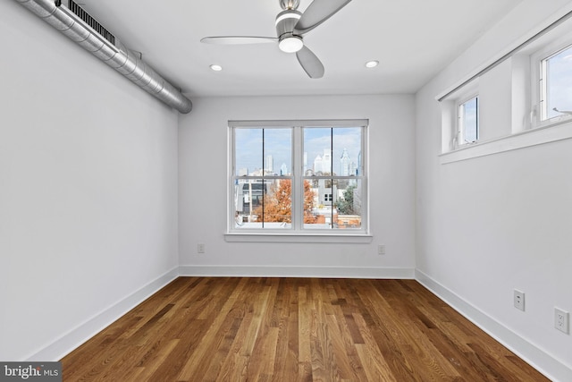 empty room featuring dark hardwood / wood-style floors, plenty of natural light, and ceiling fan