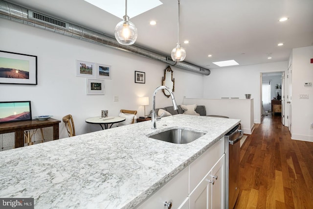 kitchen featuring light stone counters, sink, pendant lighting, white cabinets, and dark hardwood / wood-style floors