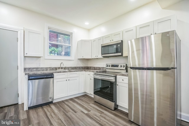 kitchen with sink, white cabinetry, stainless steel appliances, and dark hardwood / wood-style floors