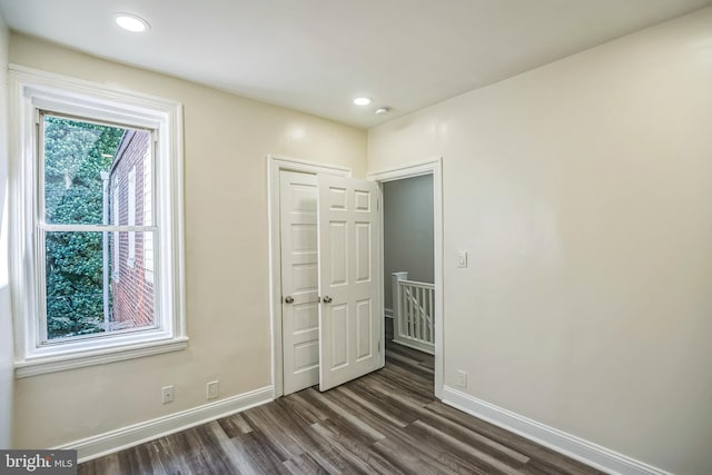 unfurnished bedroom with a closet and dark hardwood / wood-style flooring