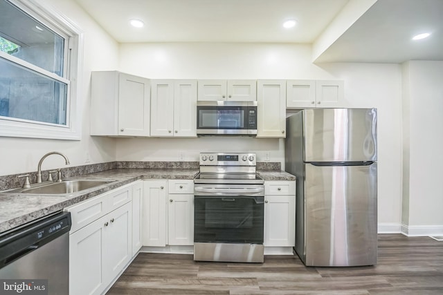 kitchen with white cabinetry, stainless steel appliances, sink, and dark hardwood / wood-style flooring