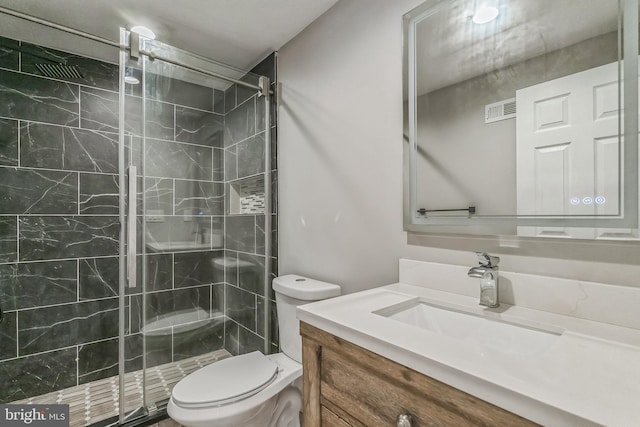 bathroom featuring vanity, toilet, and a shower with door