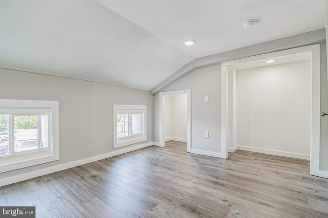 additional living space with light hardwood / wood-style floors, lofted ceiling, and plenty of natural light