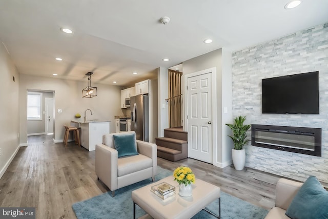 living room with sink and light wood-type flooring