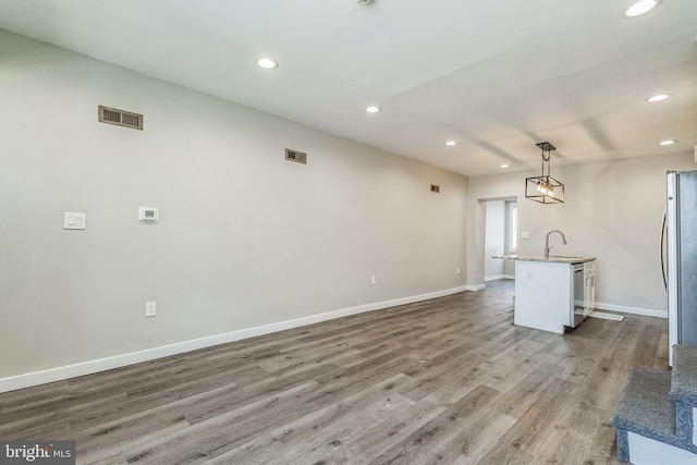 unfurnished living room featuring sink and dark hardwood / wood-style floors