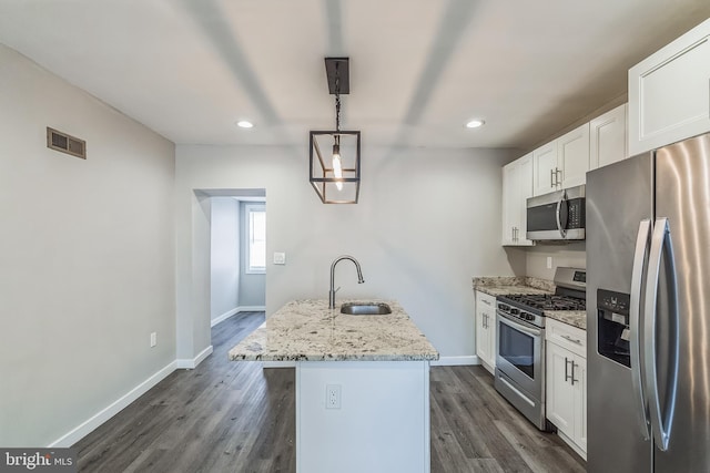 kitchen with white cabinets, a center island with sink, sink, decorative light fixtures, and stainless steel appliances