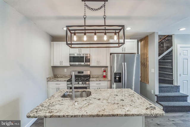 kitchen with white cabinetry, appliances with stainless steel finishes, and hardwood / wood-style floors