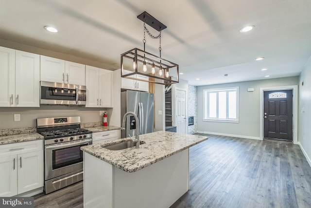 kitchen with white cabinets, a center island with sink, stainless steel appliances, and sink