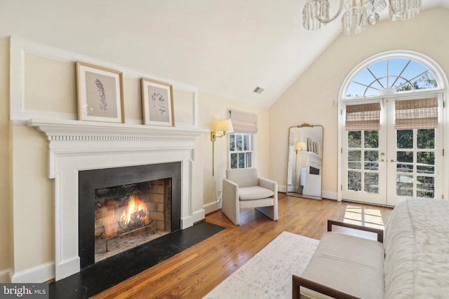 living room with wood-type flooring, french doors, and high vaulted ceiling