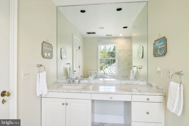 bathroom featuring a tile shower and vanity