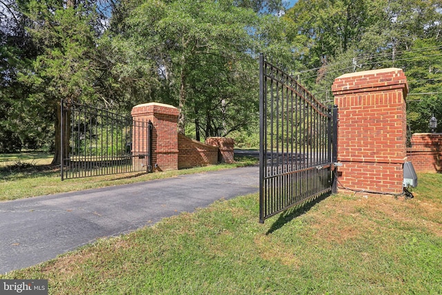 view of gate with a yard