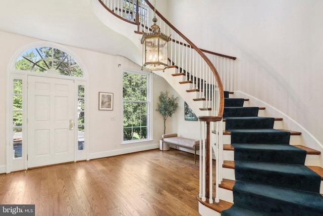 foyer entrance featuring wood-type flooring and a high ceiling